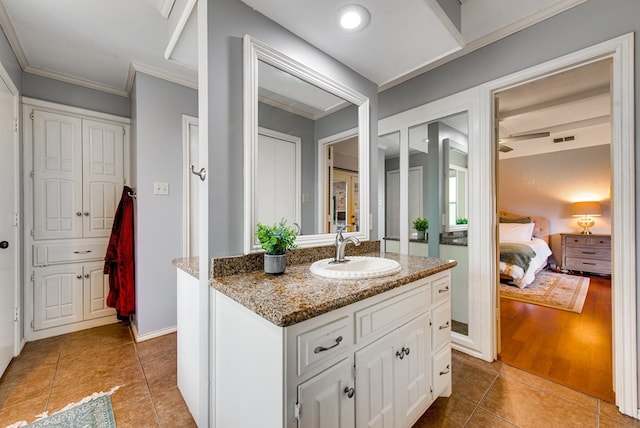 ensuite bathroom featuring connected bathroom, vanity, crown molding, visible vents, and tile patterned flooring