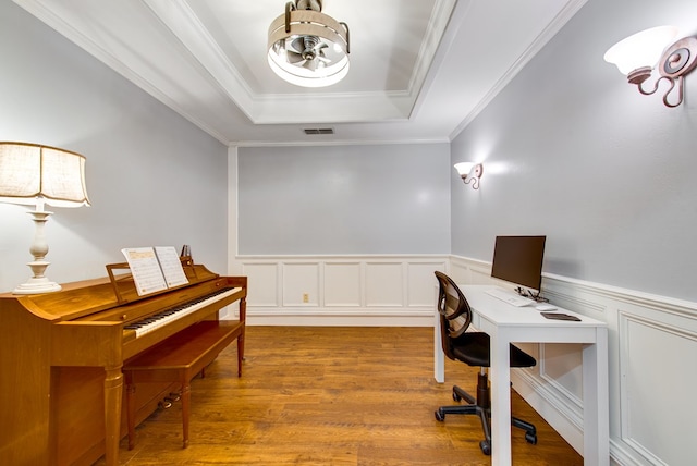 office area featuring visible vents, a tray ceiling, an inviting chandelier, wood finished floors, and wainscoting