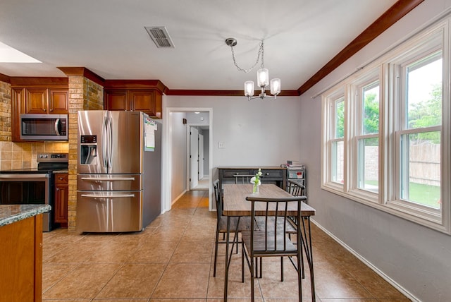 kitchen featuring brown cabinets, a chandelier, light tile patterned flooring, visible vents, and appliances with stainless steel finishes