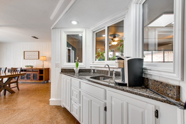 bar with light tile patterned floors, crown molding, a sink, and visible vents