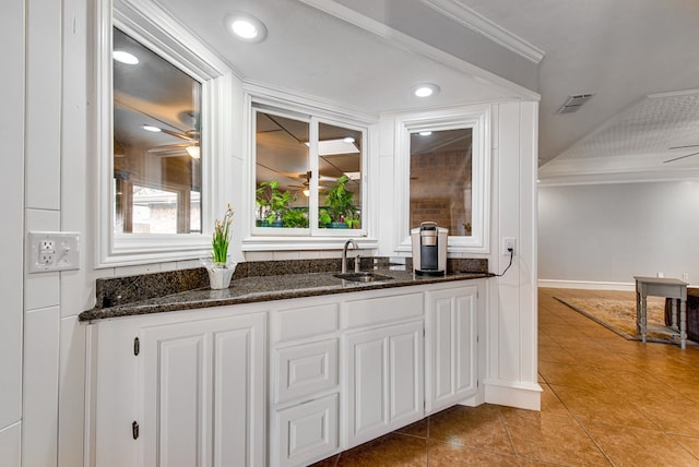 bar featuring visible vents, light tile patterned floors, ceiling fan, and a sink