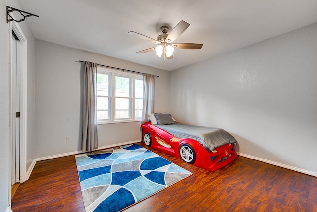 bedroom with a ceiling fan, wood finished floors, and baseboards