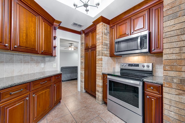 kitchen with dark stone countertops, light tile patterned floors, appliances with stainless steel finishes, backsplash, and visible vents