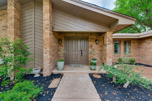 entrance to property featuring brick siding