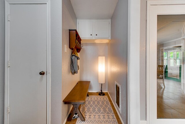 hall featuring visible vents and baseboards