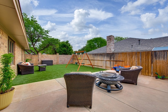 view of patio featuring a playground, a fenced backyard, and an outdoor fire pit