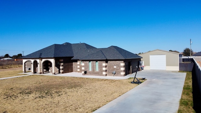 view of front of property featuring a front yard, a garage, and an outbuilding