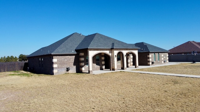 rear view of house featuring a lawn and a patio