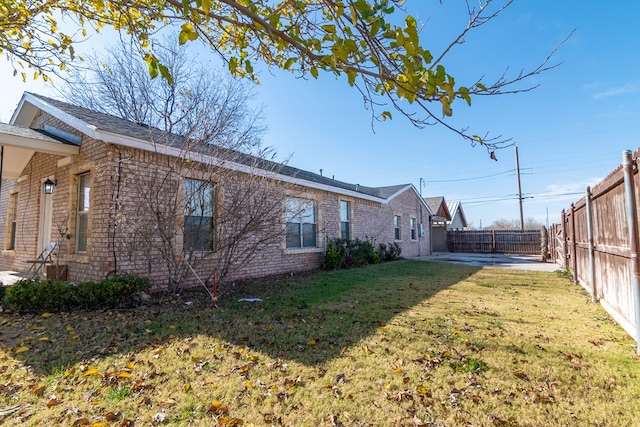 view of side of home with a yard and a patio area