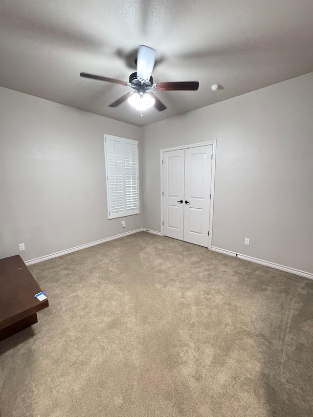 unfurnished bedroom with carpet flooring, ceiling fan, and a closet