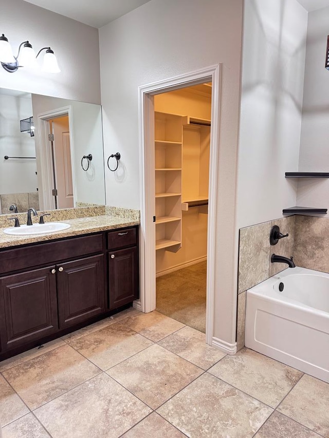 bathroom with tile patterned flooring, vanity, and a tub to relax in