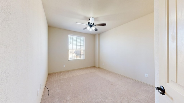 carpeted empty room featuring a ceiling fan