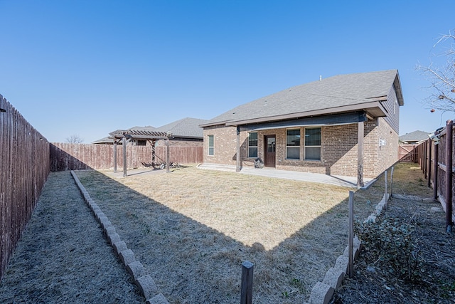 back of house with a lawn, a patio, a fenced backyard, a pergola, and brick siding