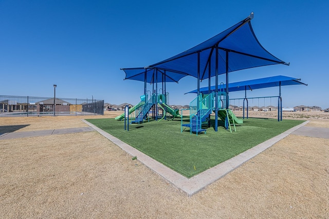 community play area featuring a yard and fence