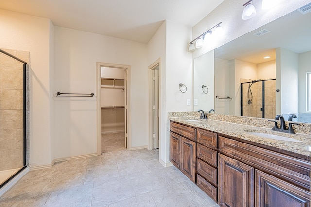 full bath with double vanity, a sink, a walk in closet, and a shower stall