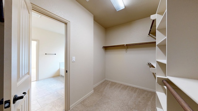 spacious closet featuring carpet floors and tile patterned flooring