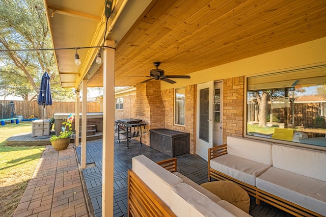 view of patio / terrace featuring a ceiling fan, a trampoline, fence, and an outdoor living space