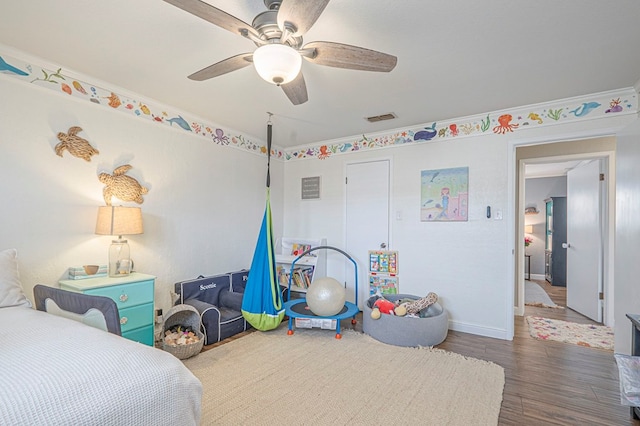 bedroom with ceiling fan, dark wood-type flooring, visible vents, and baseboards