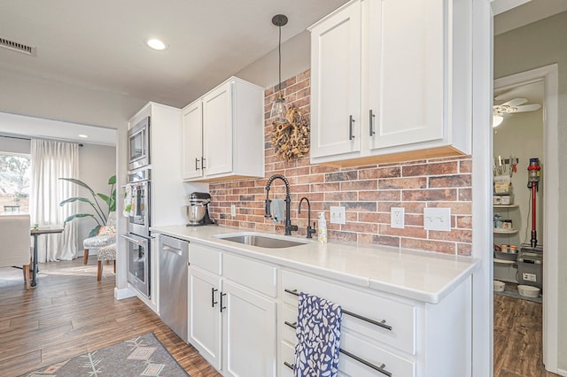 kitchen with visible vents, white cabinets, stainless steel appliances, light countertops, and a sink