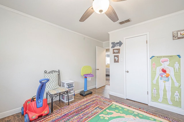 game room with baseboards, wood finished floors, visible vents, and crown molding