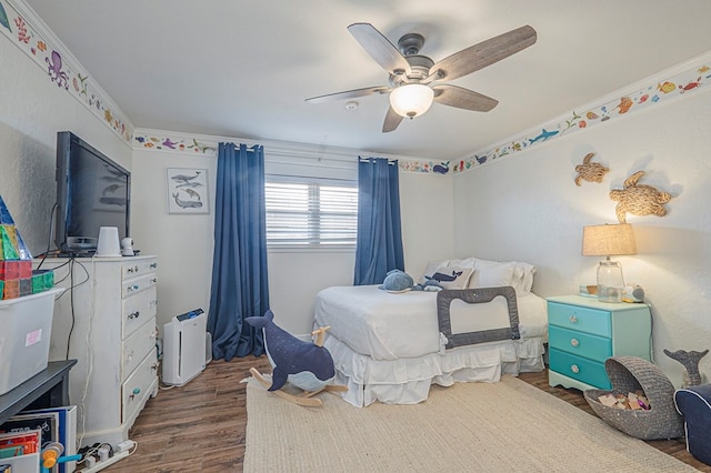 bedroom with dark wood-style floors, crown molding, and a ceiling fan