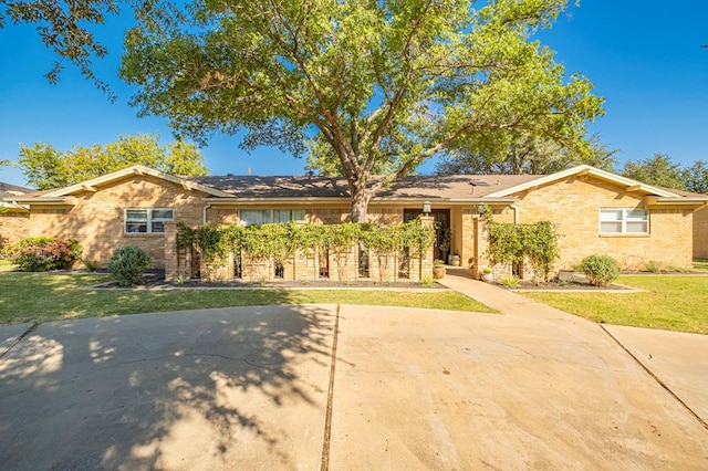 ranch-style home with brick siding and a front yard