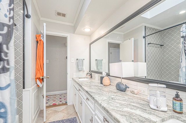 bathroom featuring ornamental molding, a skylight, visible vents, and vanity