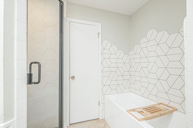 bathroom with a stall shower, tile patterned flooring, and a garden tub