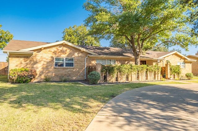 ranch-style home featuring fence, a front lawn, concrete driveway, and brick siding