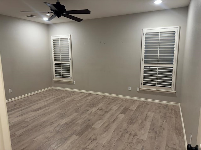 spare room with light wood-type flooring and ceiling fan