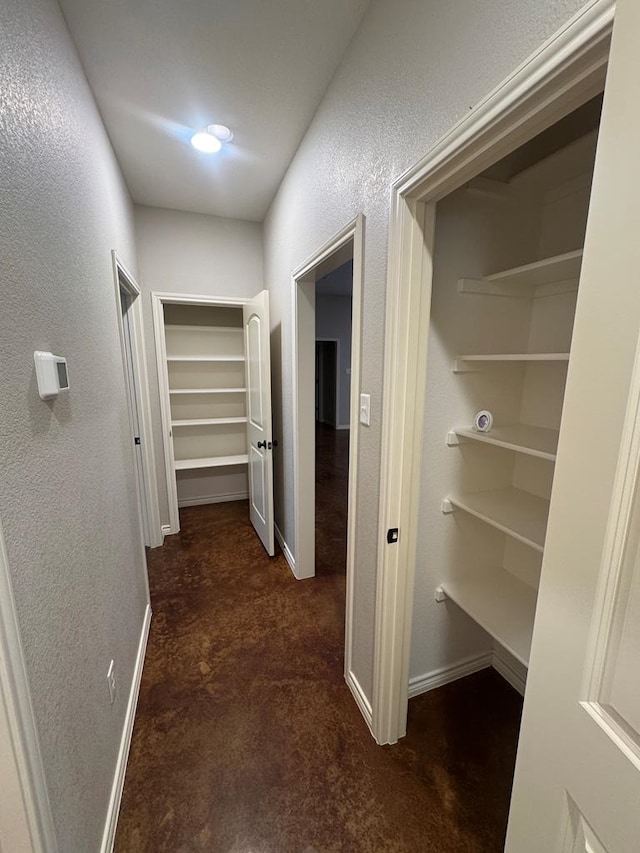 hallway with dark colored carpet