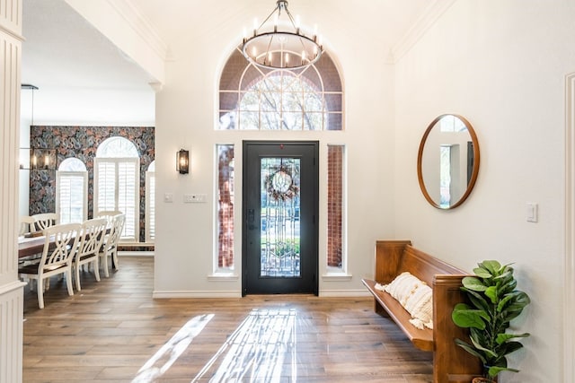 entrance foyer featuring an inviting chandelier, hardwood / wood-style flooring, and ornamental molding