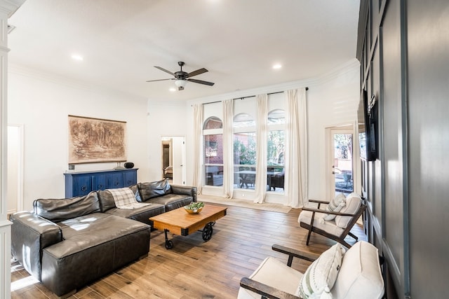 living room with crown molding, light hardwood / wood-style floors, and ceiling fan