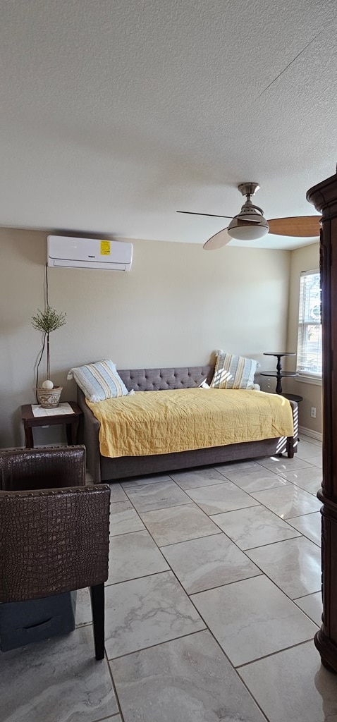 bedroom featuring a textured ceiling, ceiling fan, and a wall mounted air conditioner