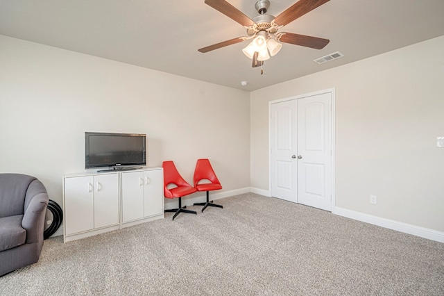 sitting room featuring light carpet and ceiling fan