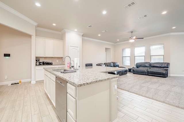 kitchen featuring a sink, light wood finished floors, dishwasher, and visible vents