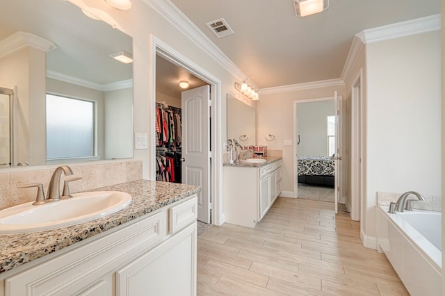 bathroom featuring wood finished floors, visible vents, plenty of natural light, and a sink