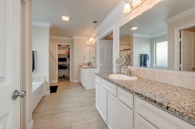 full bath with a sink, visible vents, two vanities, ornamental molding, and wood finished floors