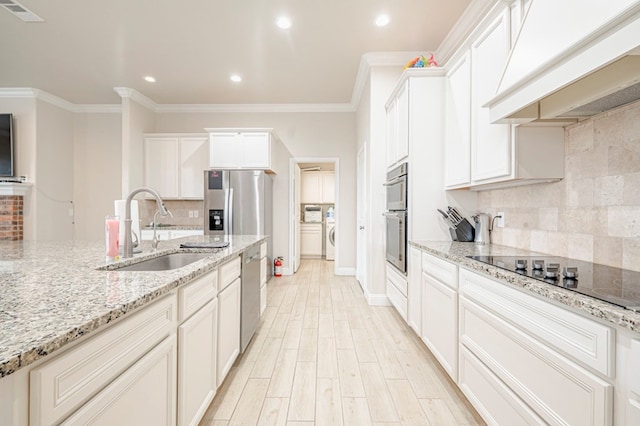 kitchen featuring stainless steel appliances, custom range hood, a sink, visible vents, and crown molding