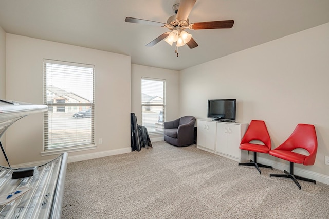 living area with baseboards, a ceiling fan, and carpet flooring