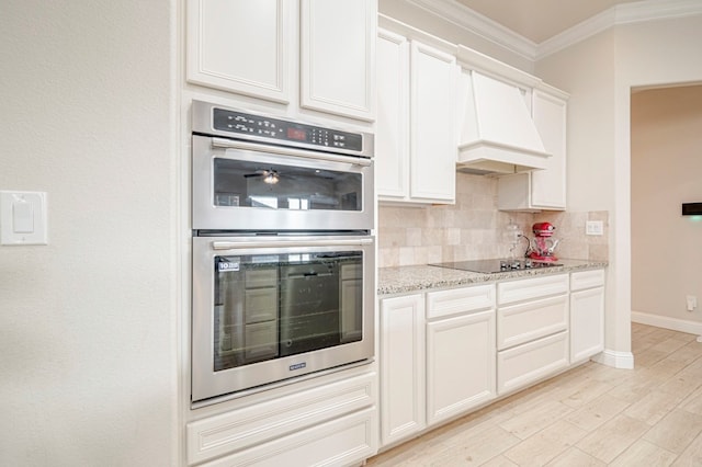 kitchen with stainless steel double oven, black electric cooktop, tasteful backsplash, crown molding, and light stone counters