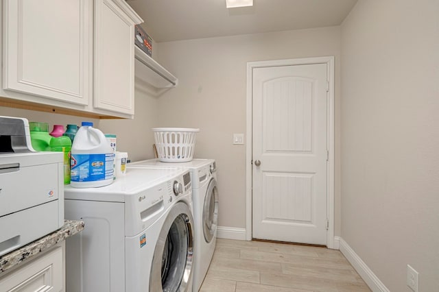 laundry area with light wood-style floors, baseboards, cabinet space, and independent washer and dryer