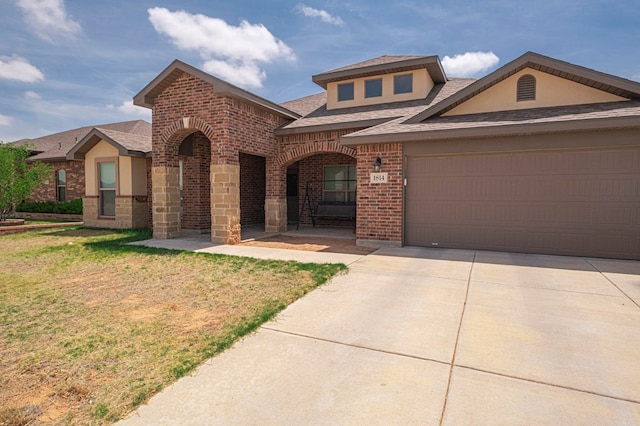traditional-style home featuring brick siding, a shingled roof, a front yard, concrete driveway, and an attached garage