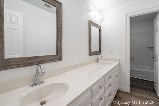 bathroom with double vanity and wood finished floors