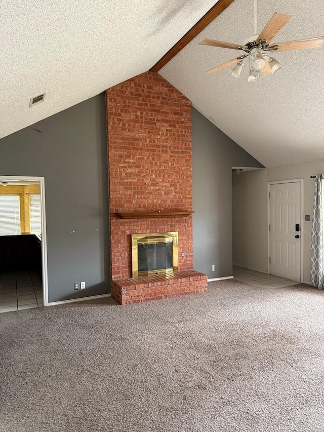 unfurnished living room featuring lofted ceiling, a textured ceiling, ceiling fan, a fireplace, and carpet