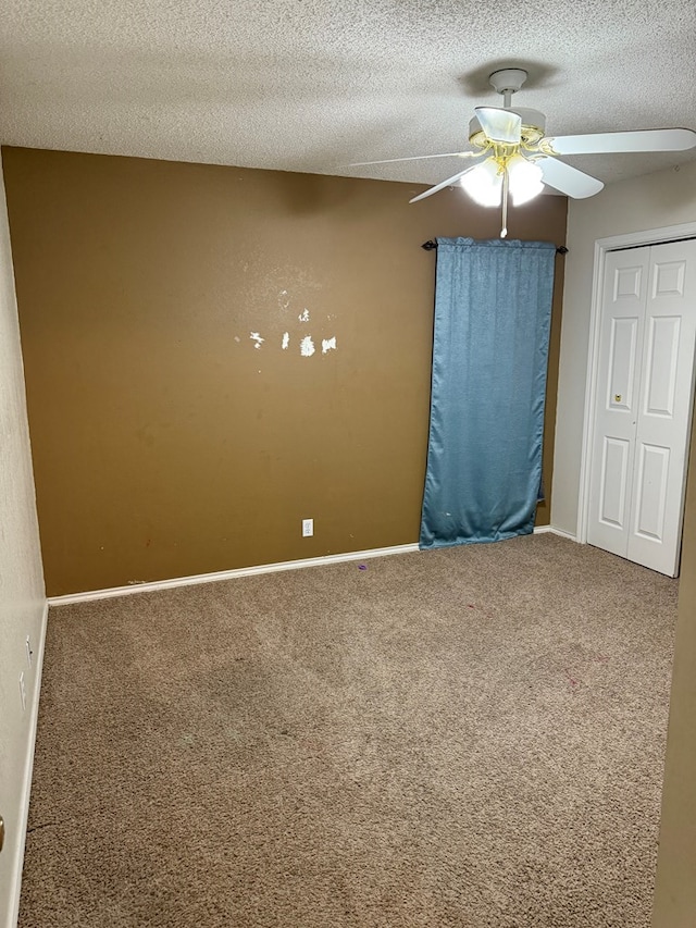 spare room with ceiling fan, carpet flooring, and a textured ceiling