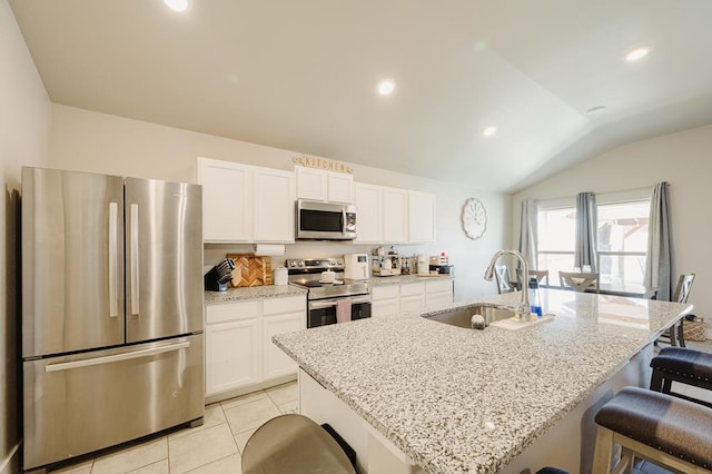 2623 E Ranch Ave, Midland, TX 79705 - kitchen featuring appliances with stainless steel finishes, vaulted ceiling, a breakfast bar, white cabinets, and light stone counters