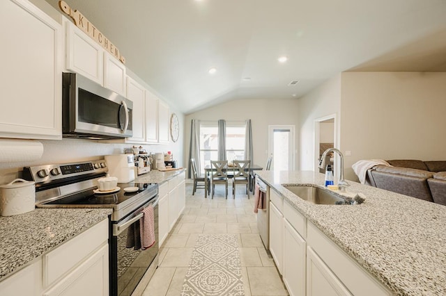 2623 E Ranch Ave, Midland, TX 79705 - kitchen with appliances with stainless steel finishes, vaulted ceiling, light stone counters, white cabinets, and open floor plan