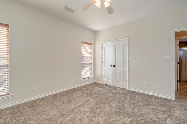 unfurnished bedroom with ceiling fan, a closet, and light carpet