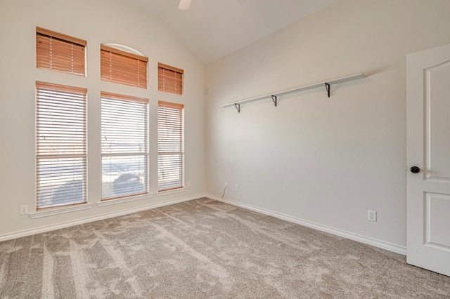 carpeted spare room featuring vaulted ceiling